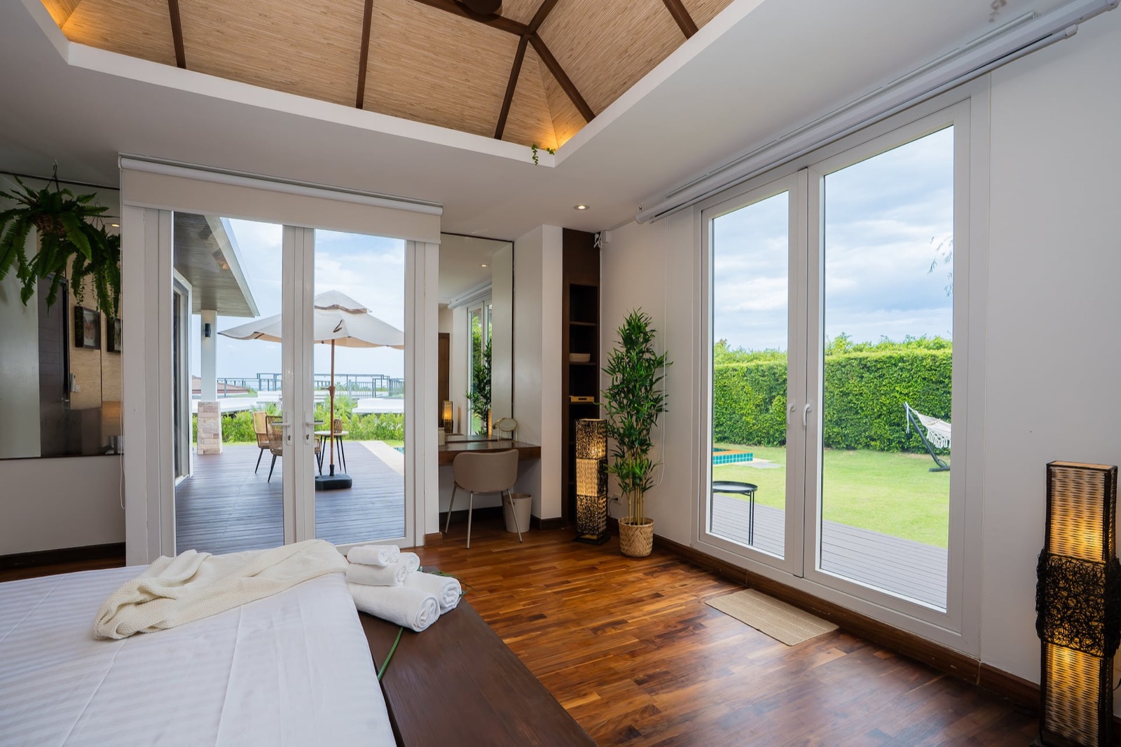 SORA 空 — Bedroom with pool views through the sliding doors