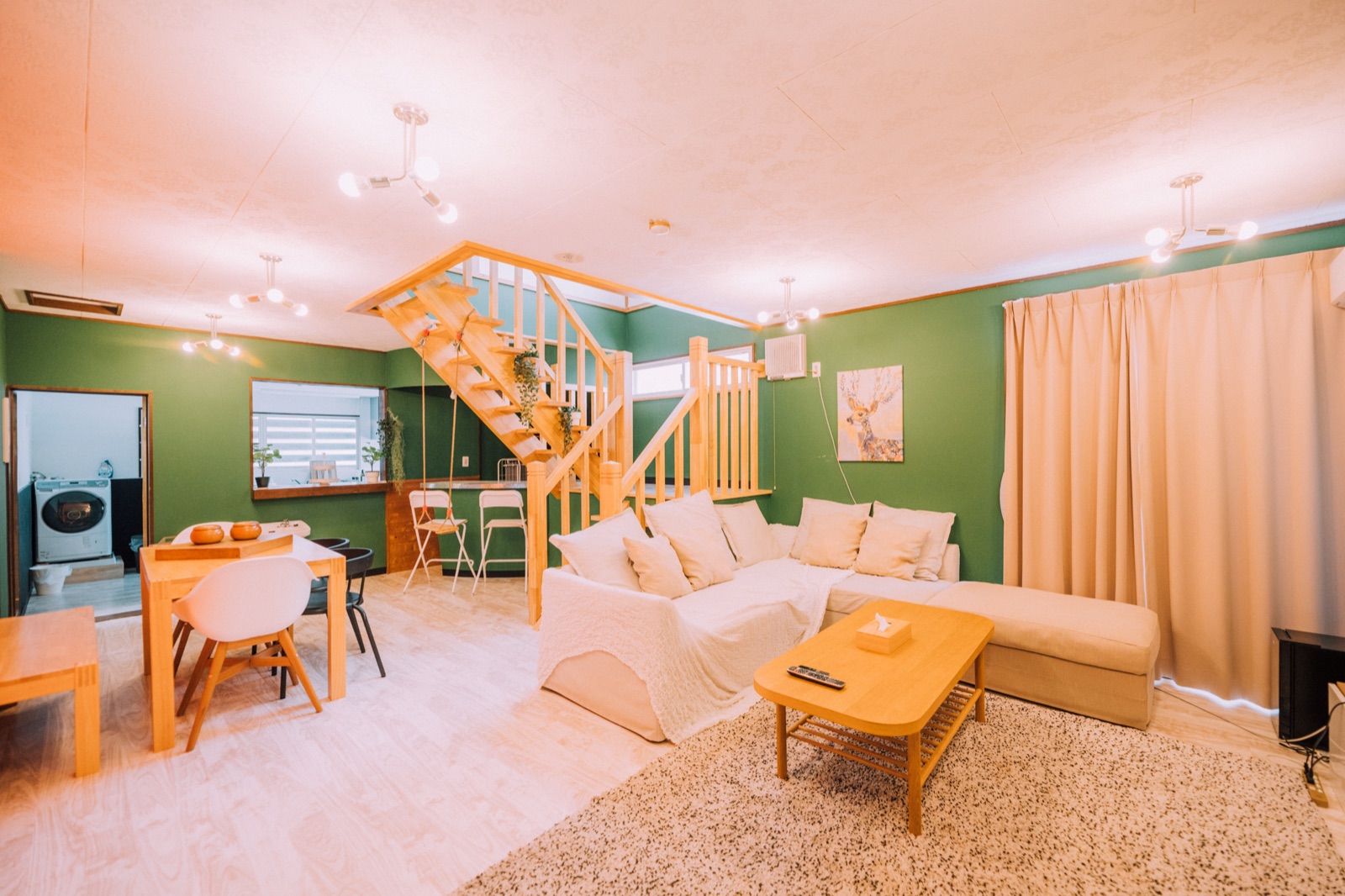 Yuzawa Onsen Lodge — House B living room — sofas, warm wood and green walls